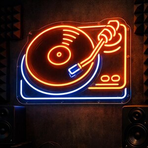 May include: Neon sign of a turntable with a glowing orange record and arm, outlined in orange and blue. The sign is mounted on a dark wall, with speakers and audio equipment visible below. A retro music theme.