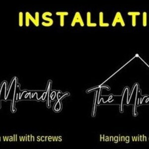 May include: Installation instructions on a black background. The word "INSTALLATION" is in yellow. The text shows two methods: mounting on a wall with screws and hanging with a chain. The brand name "The Mirandog" is in a cursive font.