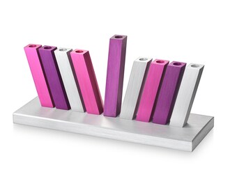 May include: A silver menorah with nine candle holders. The holders are arranged in a staggered pattern and are painted in shades of pink and purple.