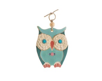 May include: A teal blue ceramic owl ornament with white and pink details. The owl has large, round, blue eyes and a small, red beak.