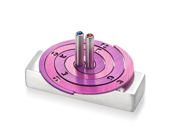 May include: A purple metal dreidel with a spiral design and Hebrew letters. The dreidel has two metal spinning tops with blue and red gemstones.