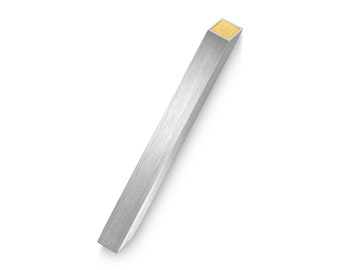 May include: A silver mezuzah with a gold-colored Hebrew letter Shin on the top.