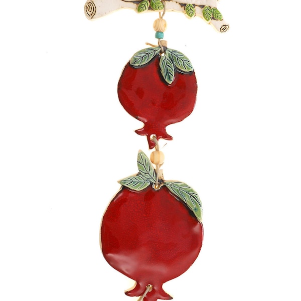 A mobile of two pomegranates on a branch