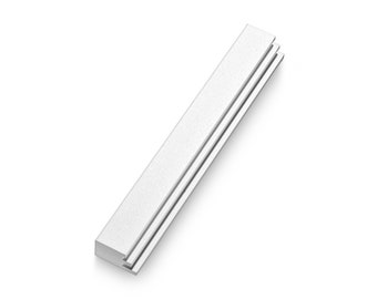 May include: A silver metal trim strip with a smooth, slightly textured surface. The strip is rectangular and has a slightly rounded edge.