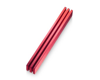 May include: Three red wooden chopsticks, stacked together, on a white background.