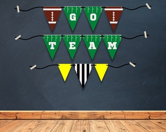 Puede incluir: Una pancarta verde y marrón con temática de fútbol con las palabras "I GO TEAM" colgada en una pared azul oscuro. La pancarta está hecha de banderas triangulares con una cuerda blanca que las conecta.