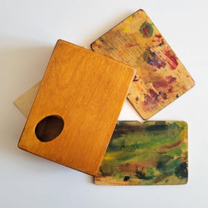 Op de afbeelding: Een set van drie keramische mokken met een gespikkelde, matte afwerking. De mokken zijn in crème, lichtgrijs en donkergrijs. Elke mok heeft een eenvoudig, minimalistisch ontwerp.