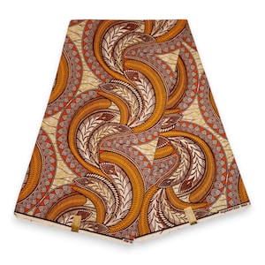 Puede incluir: Un trozo de tela doblado con un patrón repetitivo de formas de hojas naranjas, marrones y blancas. La tela tiene un fondo beige y está doblada con clips dorados. Las palabras "GUARANTEED WAX" son visibles en la esquina inferior derecha.