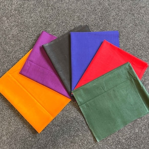 以下が含まれることがあります： オレンジ、パープル、ブラック、ブルー、レッド、グリーンの6色の布の正方形。正方形は扇形に配置されています。