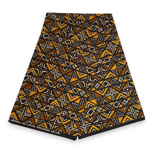Könnte beinhalten: Ein gefaltetes Stück Stoff mit einem geometrischen Muster in Braun-, Senfgelb-, Schwarz- und Weißtönen. Das Design besteht aus Dreiecken, Quadraten und gepunkteten Abschnitten. Der Text VERITABLE WAX COTTON AFRICANFABS HOLLAND ist aufgedruckt.