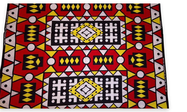 May include: A vibrant fabric with a geometric pattern in red, black, yellow, and white. The design features repeating shapes, including diamonds, triangles, and rectangles, creating a bold and eye-catching textile.