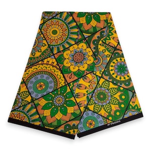 Op de afbeelding: Een gevouwen stof met een levendig, geometrisch bloemenpatroon. Het ontwerp bevat vierkanten gevuld met gestileerde bloemen in tinten geel, groen, oranje en blauw. De randen zijn afgewerkt met een zwarte rand.