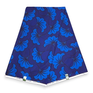Puede incluir: Una pieza de tela doblada con un patrón repetitivo de motivos florales en forma de abanico azul brillante sobre un fondo azul marino oscuro. Los bordes blancos muestran el texto impreso Veritable Wax Hollandais Vlisco y Dutch Wax Vlisco.