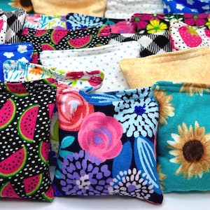 May include: A collection of colorful fabric squares with various patterns, including watermelon, flowers, and sunflowers. The squares are sewn together to create a patchwork design.
