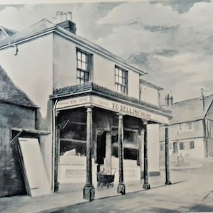 May include: Black and white painting of a building with a covered entrance supported by columns. The building has a sign that reads "F.C. BELLINGHAM". A smaller building is to the left, and a house is in the background.