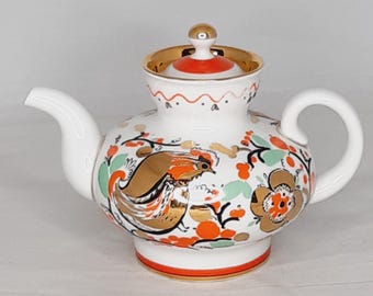 以下が含まれることがあります： 赤い金色の花柄が描かれた白い磁器製のティーポット。鳥が描かれている。ティーポットには金色のつまみ付きの蓋が付いている。
