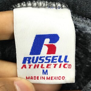 May include: White tag with a red and blue "R" for Russell Athletic. The tag also says "Made in Mexico" and "M" for size.