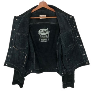 Puede incluir: Chaqueta de ante negro con una etiqueta Diesel en el interior. La etiqueta dice "Industry Recommended Leather Real 100%".