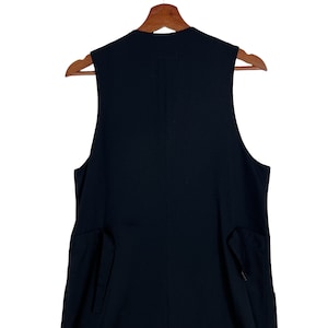 May include: A black sleeveless vest with a high neckline and two pockets on the sides.