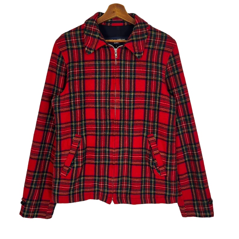 May include: Red and black plaid jacket with a zipper closure. The jacket has a collar and two pockets.