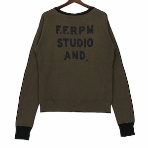 Könnte beinhalten: Ein grüner Langarm-Pullover mit schwarzem Besatz an Hals und Ärmeln. Auf der Rückseite des Pullovers ist der Text "F.F.R.P.M STUDIO AND" in Schwarz gedruckt.