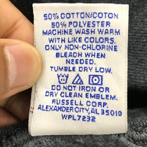 May include: White care label with blue text. 50% Cotton/Cotton 50% Polyester. Machine wash warm with like colors. Only non-chlorine bleach when needed. Tumble dry low. Do not iron or dry clean emblem. Russell Corp. Alexander City, AL 35010 WPL 7232.