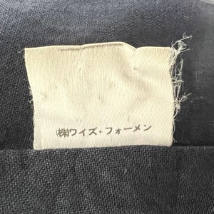 May include: A white fabric label with the text "(株)ワイズ・フォーメン" in black.