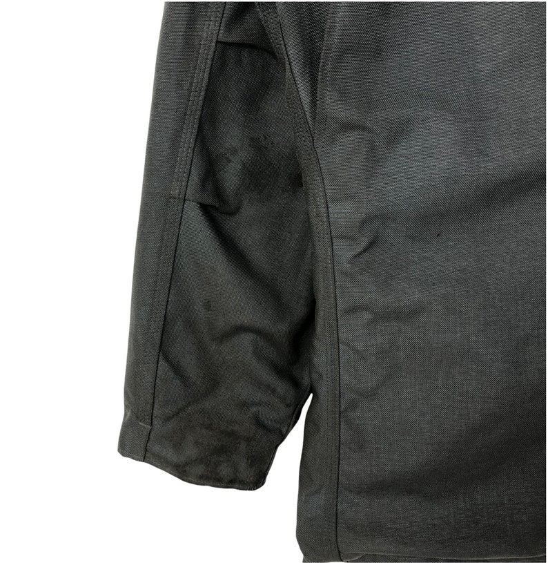 May include: A dark gray jacket with a zipper closure and a seam down the center of the back. The jacket has a slightly textured fabric.