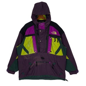 May include: A purple, green, and black The North Face ski jacket with a hood. The jacket has a zipper closure and multiple pockets.