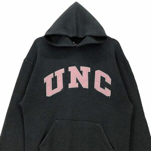 May include: A dark gray hooded sweatshirt with a pink UNC logo.