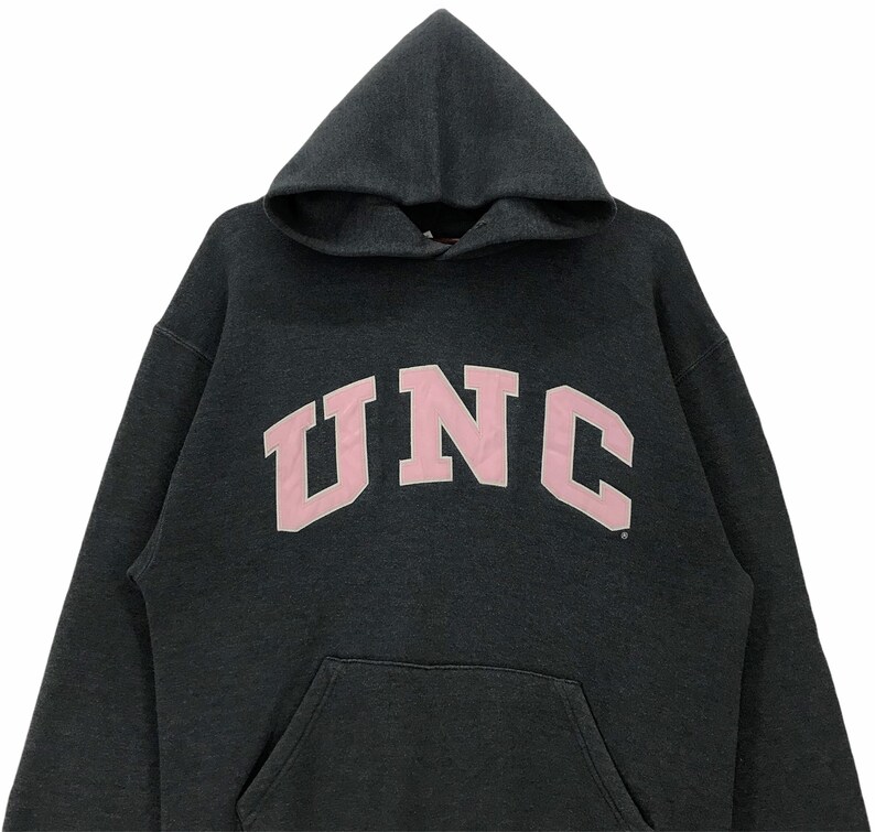 May include: A dark gray hooded sweatshirt with a pink UNC logo.