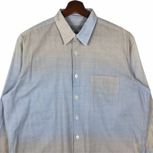 Op de afbeelding: Een lang mouw ombre overhemd met knopen, met een lichte blauwe tot beige gradi&euml;nt. Het overhemd heeft een borstzak en een knoopsluiting.