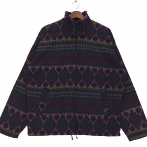 May include: A brown, purple, and green patterned fleece pullover with a half-zip closure and a kangaroo pocket.