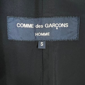 May include: Black label with white text that reads "COMME des GARCONS* HOMME S".