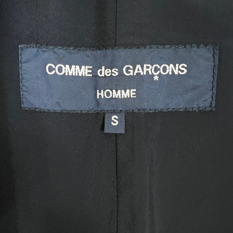 May include: Black label with white text that reads "COMME des GARCONS* HOMME S".