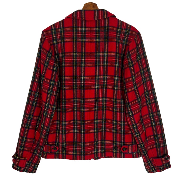 May include: Red and black plaid jacket with a zipper closure and button accents. The jacket has long sleeves and a collar.