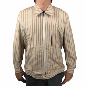 K&ouml;nnte beinhalten: Eine beige gestreifte Jacke mit Rei&szlig;verschluss und einer kleinen Tasche auf der linken Seite.