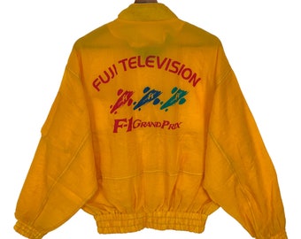 May include: A yellow jacket with a red, blue, and green logo that says "Fuji Television F1 Grand Prix".