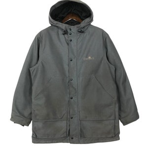 May include: A gray Carhartt hooded jacket with a button front closure and two large pockets on the front. The jacket has a logo on the left chest that says "Carhartt".