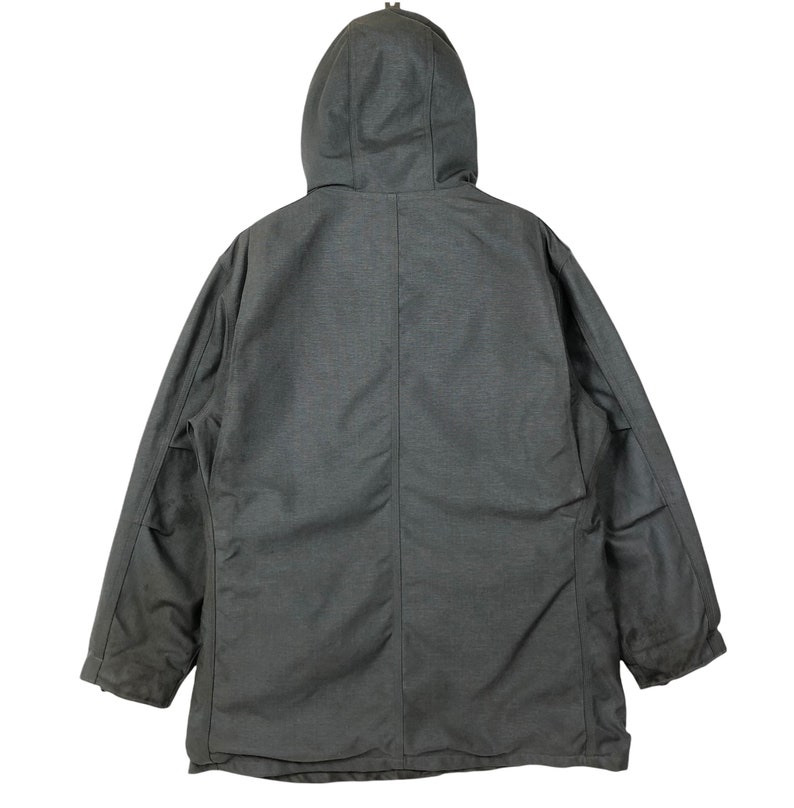 May include: A dark gray hooded jacket with a zipper closure and two pockets on the front. The jacket has a quilted lining and a drawstring hood.