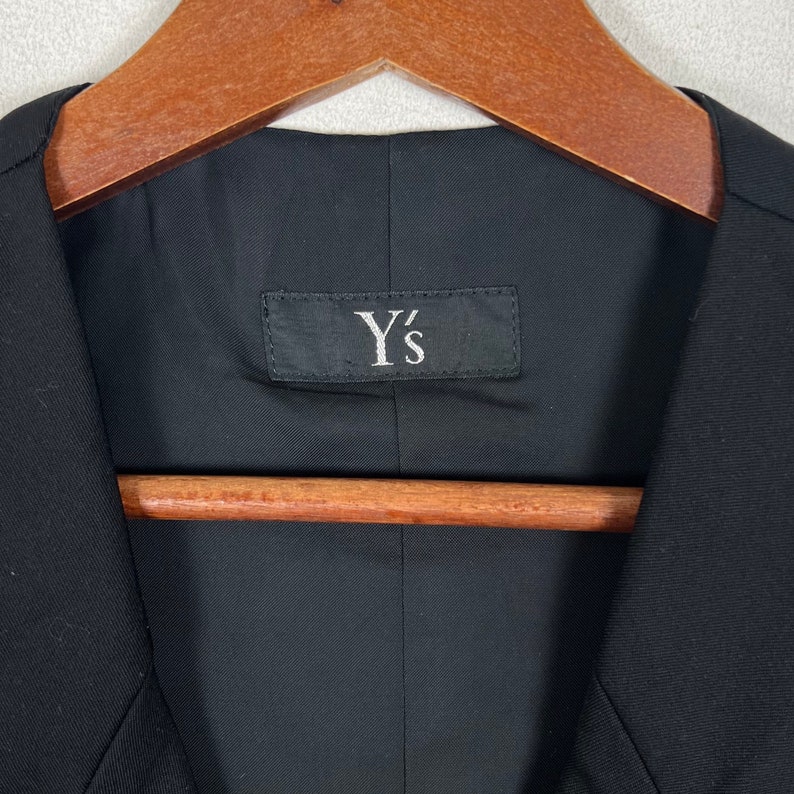 May include: A black blazer with a Y's label on the inside.