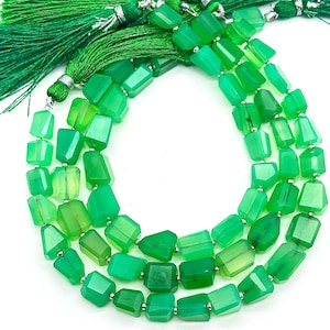 Puede incluir: Una hebra de cuentas de piedras preciosas verdes, cada cuenta está facetada y tiene una forma rectangular. Las cuentas están enhebradas en un alambre de plata y están separadas por pequeños separadores de plata.