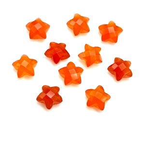 May include: Ten orange star-shaped carnelian gemstone beads. The beads are faceted and have a smooth, polished finish.