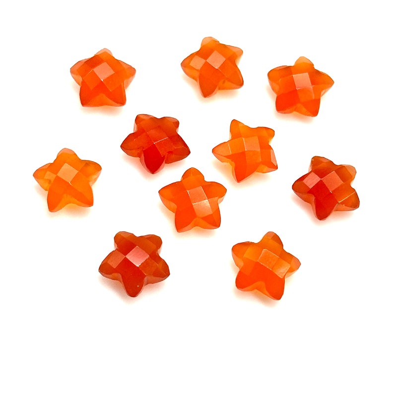 May include: Ten orange star-shaped carnelian gemstone beads. The beads are faceted and have a smooth, polished finish.