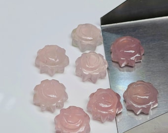 Puede incluir: Ocho cabujones de piedra preciosa de forma estrellada, de color rosa y tallados. Cada cabujón presenta un diseño de sol tallado.