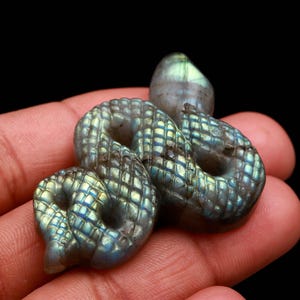 Könnte beinhalten: Eine weiße Keramik-Tasse mit schwarzem Henkel und dem Text "But First, Coffee" in fetter, schwarzer Schrift. Die Tasse steht vor einem verschwommenen Hintergrund, der ihr klares Design hervorhebt.