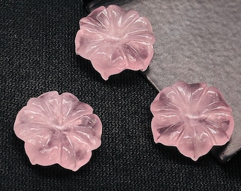Könnte beinhalten: Drei rosafarbene, blumenförmige Edelsteinkabochons. Die Cabochons sind durchscheinend und haben eine glatte, polierte Oberfläche.