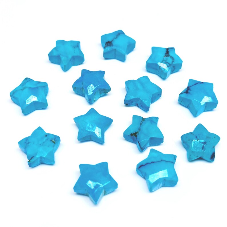 May include: A selection of turquoise star-shaped gemstones. Each stone has a faceted surface and a vibrant blue colour with darker veining. The stars are arranged on a white background, highlighting their unique shapes and natural variations.
