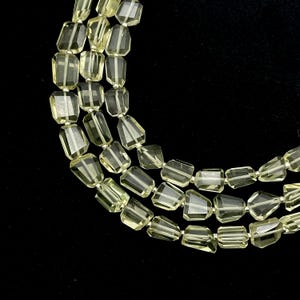 May include: A strand of light green faceted gemstone beads. The beads are rectangular in shape and have a smooth, polished finish.