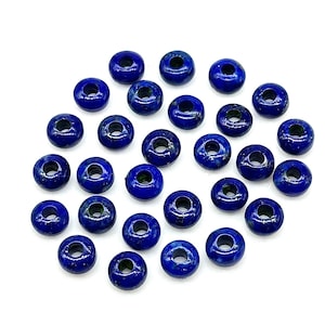 May include: A collection of 30 round, dark blue lapis lazuli beads with a hole in the center. The beads are approximately 1/2 inch in diameter.